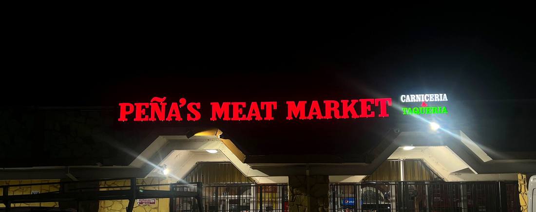 Peña's Meat Market lit channel letters at night
